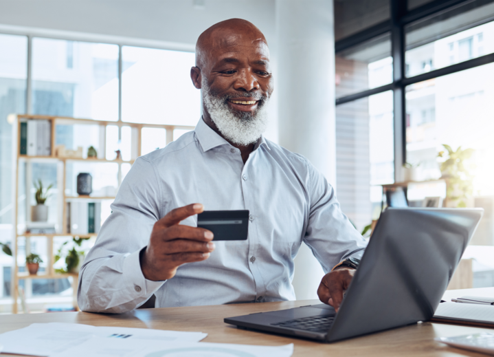 Happy black man, business credit card learning why you need a business banking account and laptop for ecommerce, finance and accounting in office.